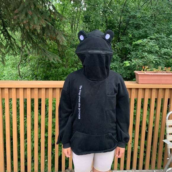 A frog hoodie that has the words “the frog kisses the princess” on it. - Picture 2 of 5